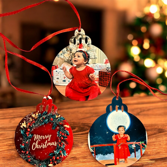 Personalized Christmas ornaments with a child in a red dress on a wooden surface.